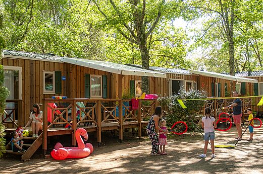Houten stacaravans, families spelend op camping CAPFUN Palombière in SAINT-NATHALENE (24).