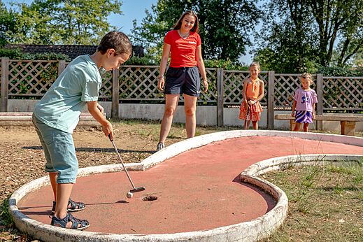 Kind speelt minigolf op de baan van camping CAPFUN Palombière in SAINT-NATHALENE (24).