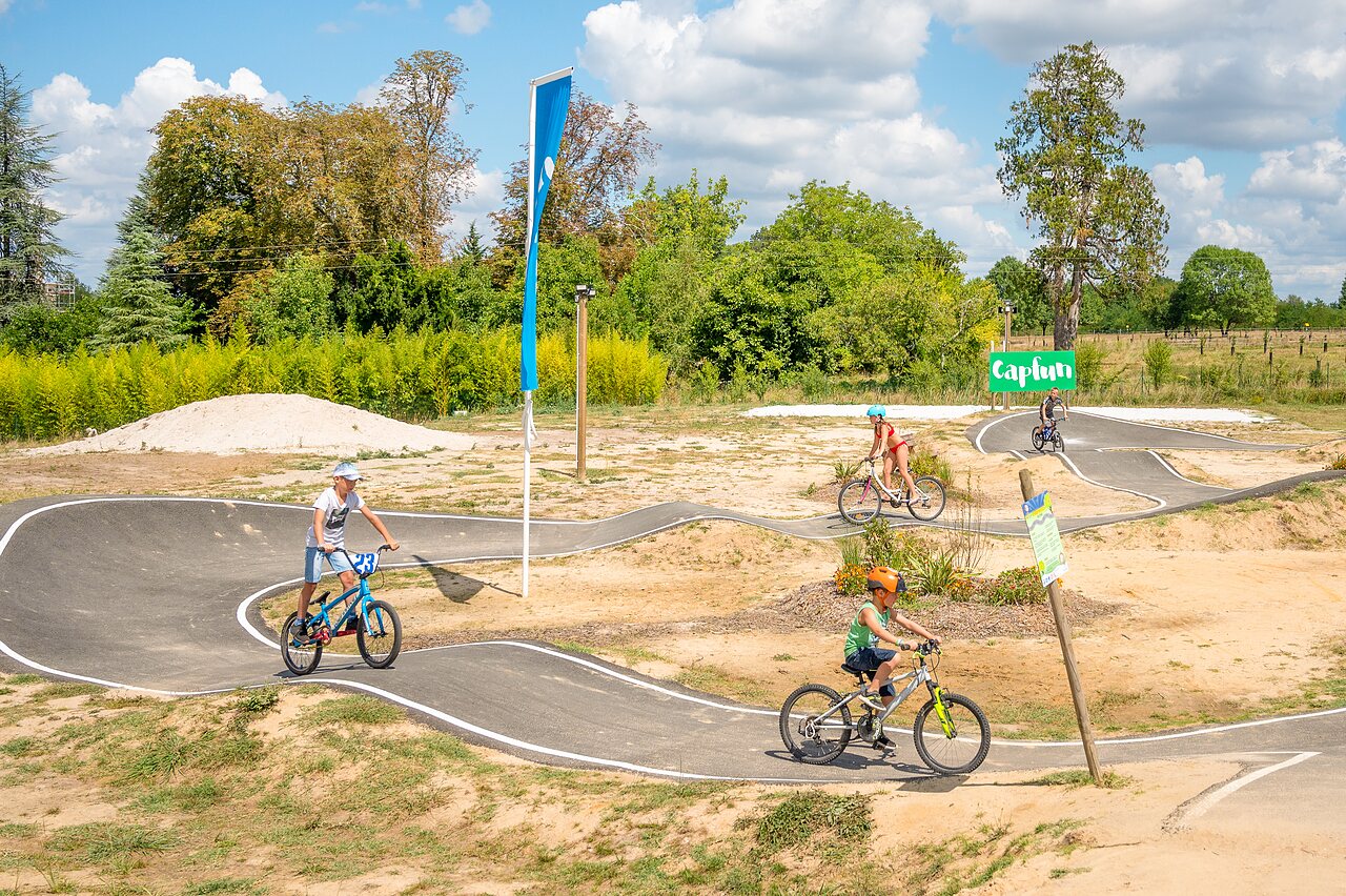 Pumptrack en fietsende kinderen op camping CAPFUN Paradis de Bazas in BAZAS (33).