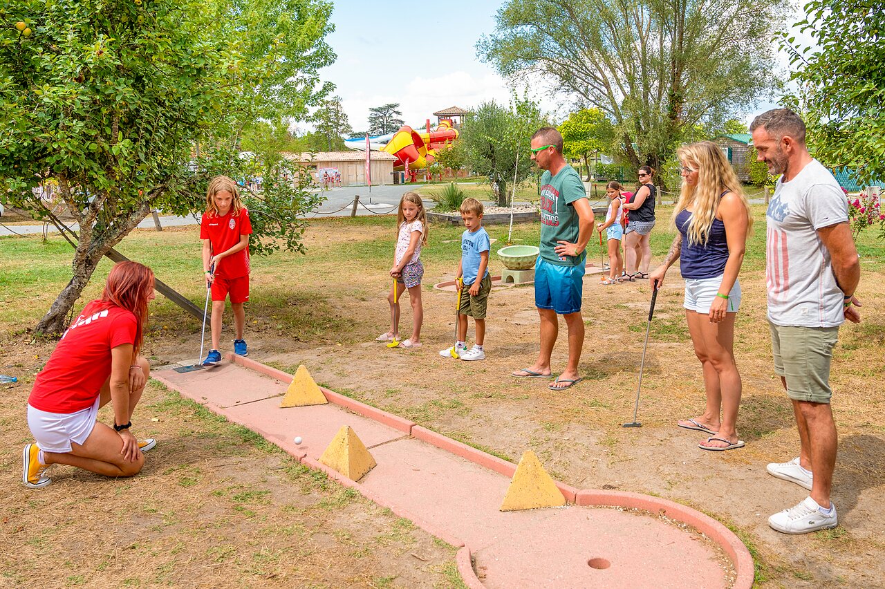 Familie en kinderen spelen minigolf met animator op camping CAPFUN Paradis de Bazas in BAZAS (33).