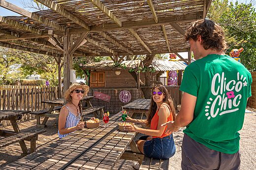 Overdekte buitenbar, picknicktafels op camping CLICOCHIC Paradou in Marseillan-Plage.