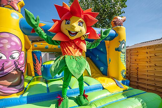 Mascotte en opblaasbaar speeltoestel voor kinderen op camping CLICOCHIC Paradou Marseillan-Plage.