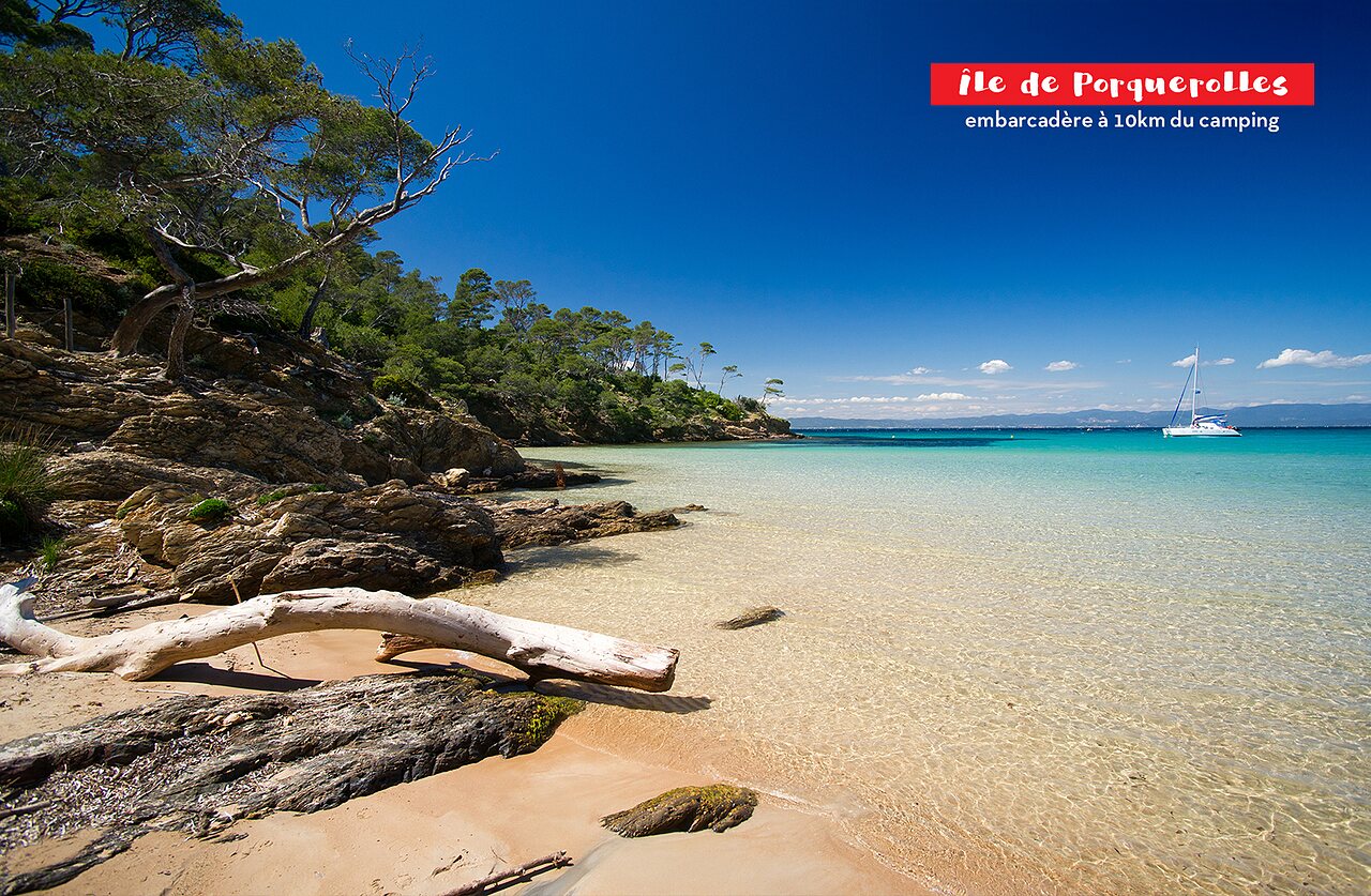 Paradijselijk strand van �le de Porquerolles, turquoise water en rotsachtige kust.