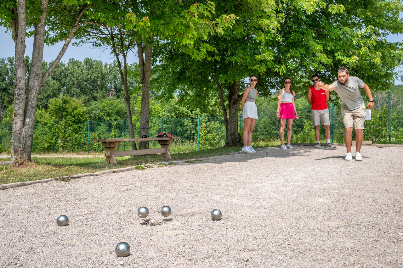 Schaduwrijke jeu de boules baan met vakantiegangers, op camping CAPFUN Pergola in Marigny (39).
