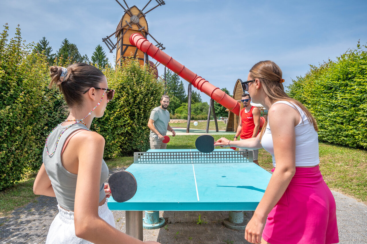 Jongeren spelen buiten tafeltennis, reuzenglijbaan op camping CAPFUN Pergola in Marigny.