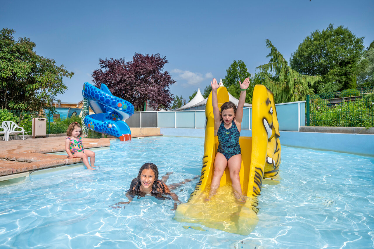 Buitenzwembad met waterglijbanen en kinderen op camping CAPFUN Pergola in Marigny (39).