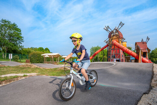 Kind op fiets op pumptrack, speelzone CAPFUN Pergola in Marigny (39).
