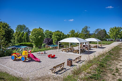 Kleurrijke speeltuin met glijbaan en schommel op camping CAPFUN Pergola in Marigny (39).