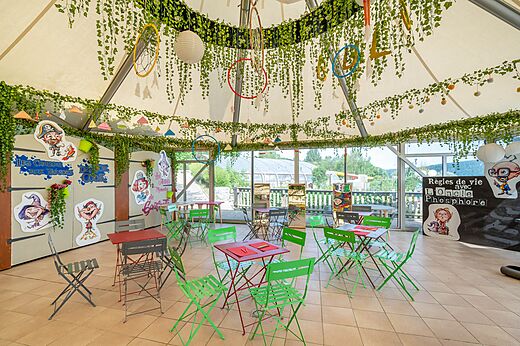 Versierde animatieruimte voor kinderen met tafels en stoelen op camping CAPFUN Pergola in Marigny (39).