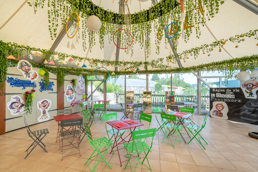 Versierde animatieruimte voor kinderen met tafels en stoelen op camping CAPFUN Pergola in Marigny (39).