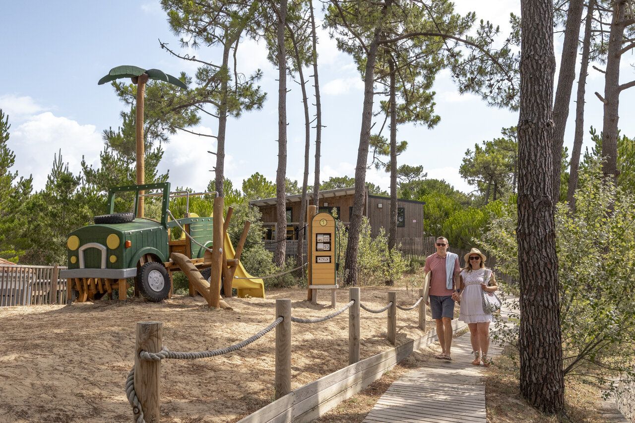 Jeep-vormige speeltuin en wandelend stel op camping CLICOCHIC Petit Bec in St Hilaire de Riez (85).