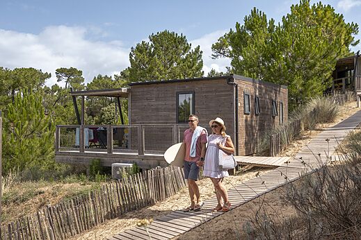 Houten Mobil-home, stel op zandpad op camping CLICOCHIC Petit Bec in St Hilaire de Riez.