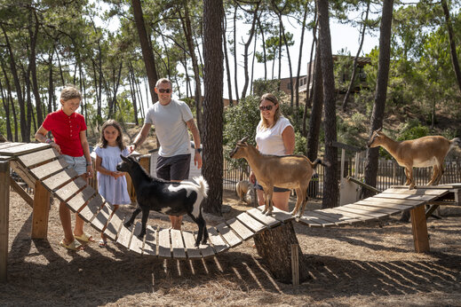 Familie en kinderen aaien geiten op de kinderboerderij van camping CLICOCHIC Petit Bec in St Hilaire de Riez (85).
