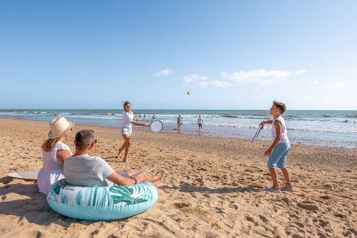 Familie speelt strandtennis op het zandstrand van camping CLICOCHIC Petit Bec in St Hilaire de Riez (85).
