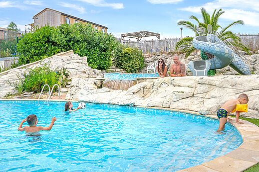 Buitenzwembad met glijbaan en gezin genietend van het zwemmen op camping CLICOCHIC Petit Nice in PYLA SUR MER (33).