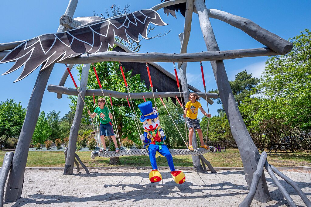 Reuzenschommel met kinderen en mascotte op camping CAPFUN Pin�da in CAZAUX (33).