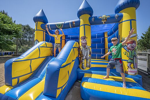 Opblaasbaar kasteel met lachende kinderen op camping CAPFUN Pinèda in CAZAUX (33).