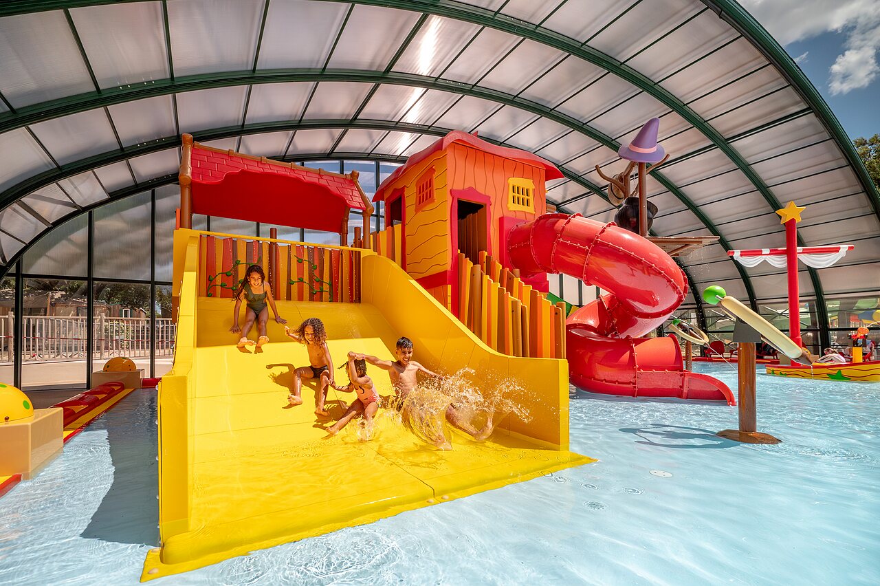 Waterglijbanen en waterspeeltuin voor kinderen in het overdekte zwembad op camping CAPFUN Pin�des du Luberon in PERTUIS (84).