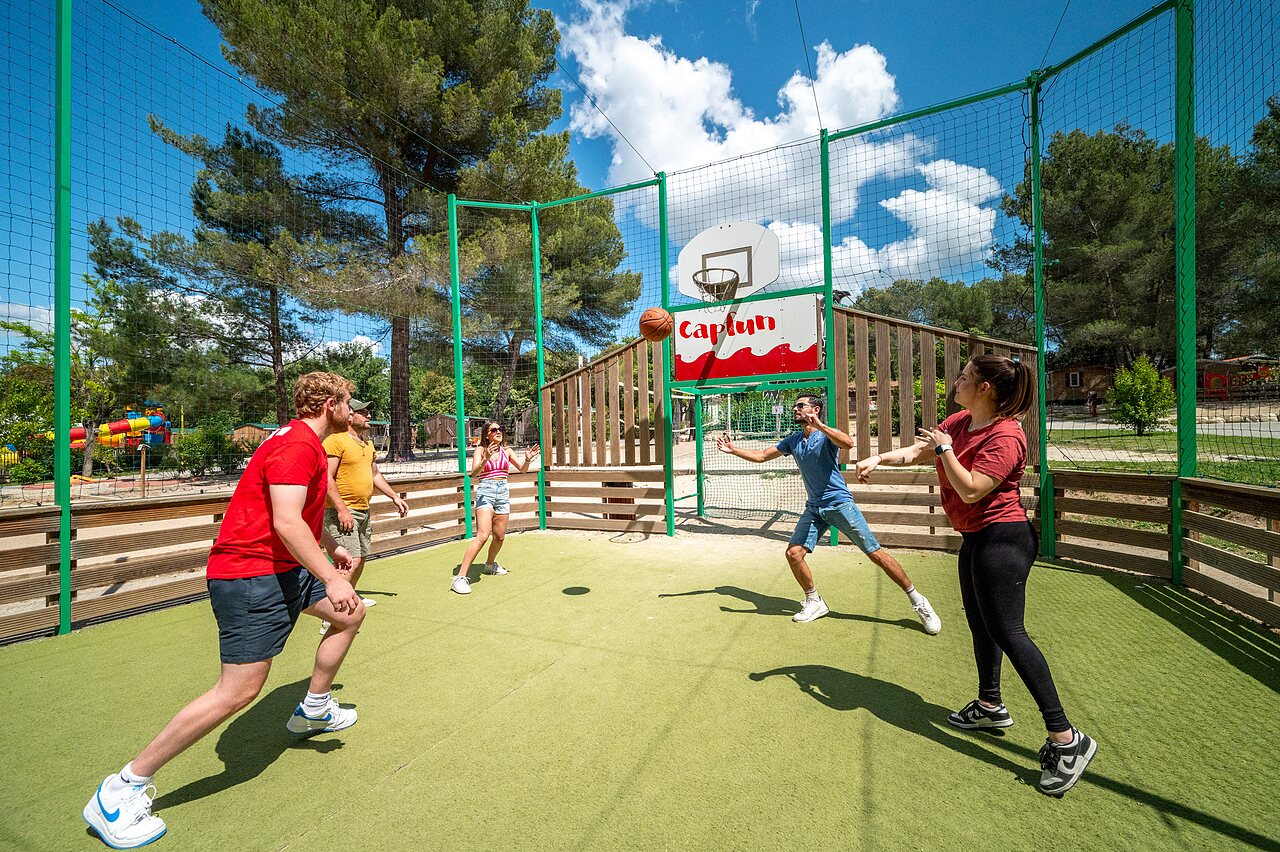 Multisportterrein, vrienden spelen basketbal op camping CAPFUN Pin�des du Luberon (84).