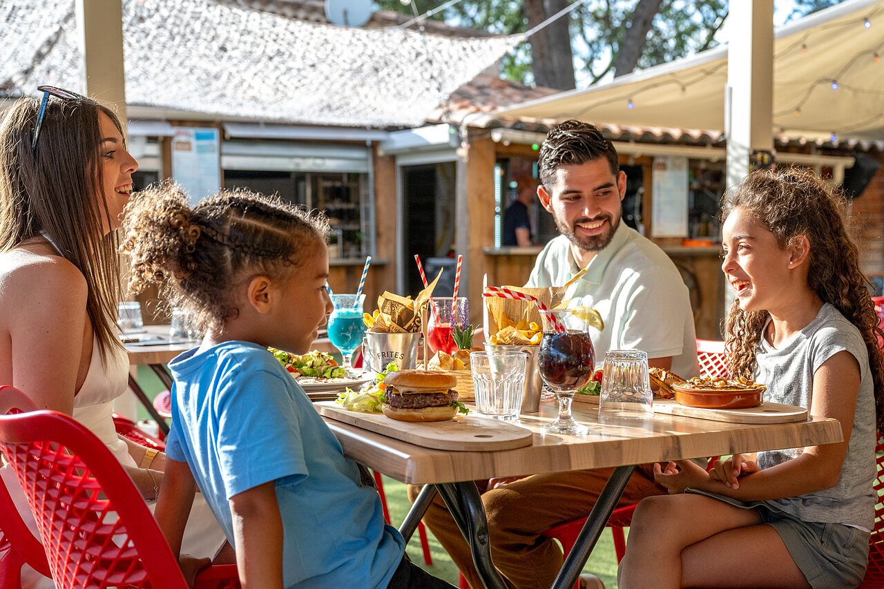 Lachende familie luncht in restaurant camping CAPFUN Pin�des du Luberon te PERTUIS (84).