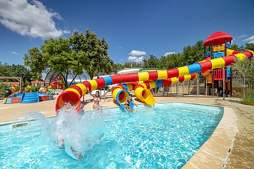 Kleurrijke waterglijbanen en buitenzwembad op camping CAPFUN Pin�des du Luberon, PERTUIS (84).