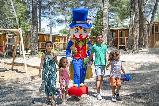 Mascotte en lachende kinderen wandelen op camping CAPFUN Pinèdes du Luberon in PERTUIS (84).