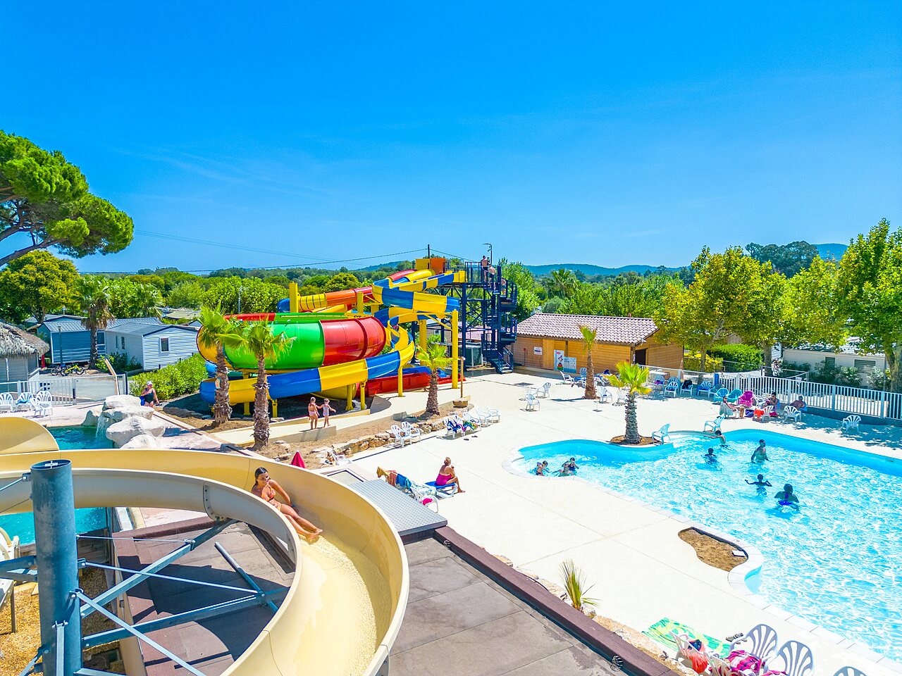 Kleurrijke waterglijbanen en buitenzwembad op camping CAPFUN La Pin�de de Grimaud (83).