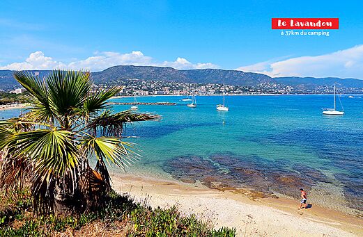 Zandstrand en turquoise zee met zeilboten in Le Lavandou, Côte d'Azur.