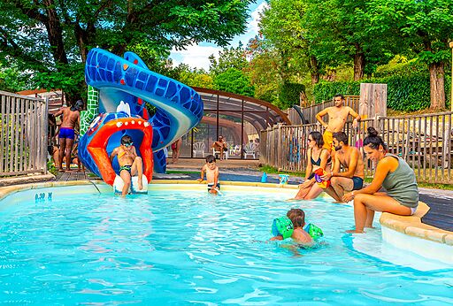 Waterglijbaan en buitenzwembad met kinderen op CAPFUN Plantas in SAINT VINCENT DE DURFORT (07).