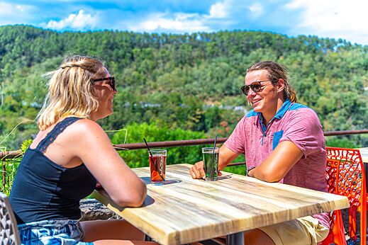 Lachend stel drinkt op terras, CAPFUN Plantas, SAINT VINCENT DE DURFORT (07).