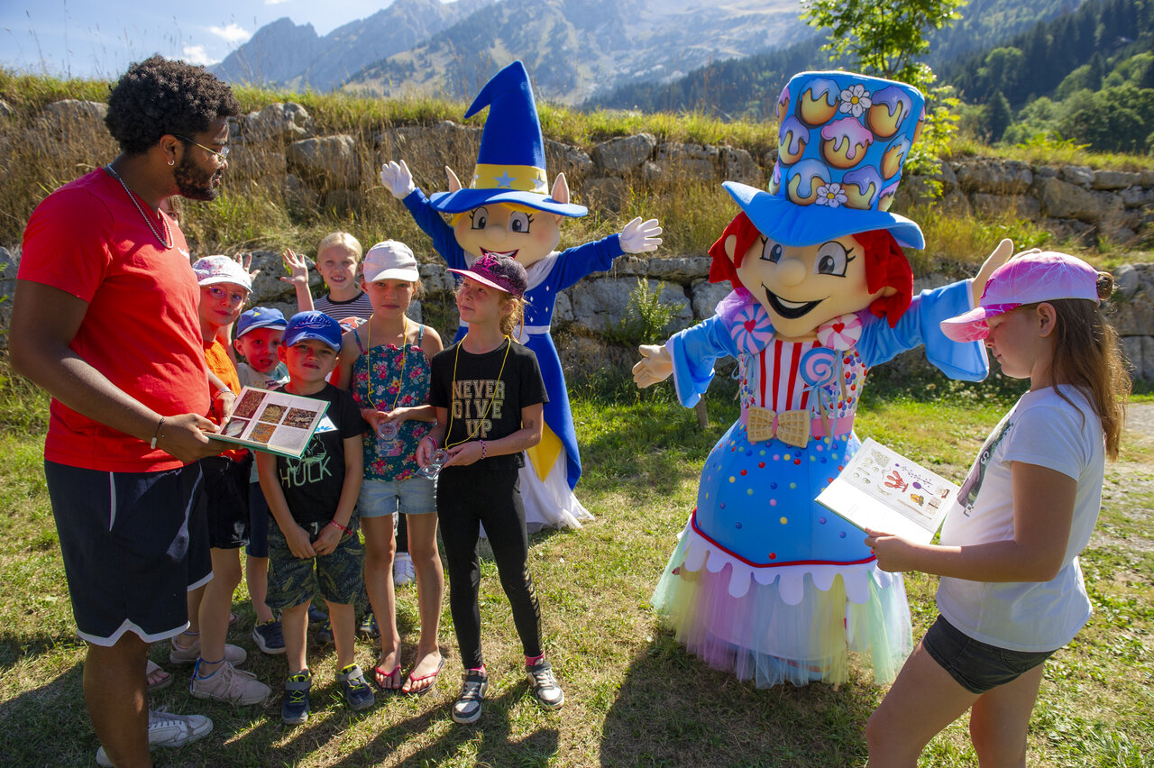 Animator, kinderen en mascottes tijdens buitenactiviteit op camping CAPFUN Plan du Fernuy in LA CLUSAZ (74).