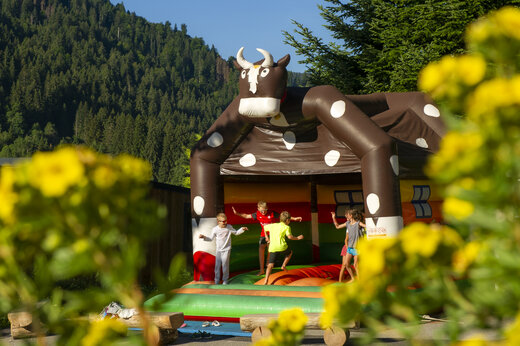 Kinderen spelen op opblaasbaar koe-spel op camping CAPFUN Plan du Fernuy.