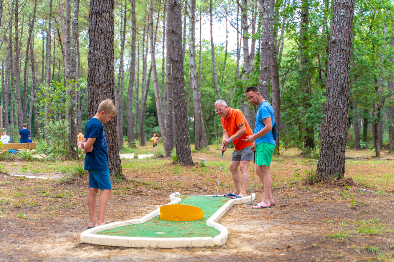 Familie speelt minigolf in bos, camping CAPFUN Pomme de Pin in Saubion (40).