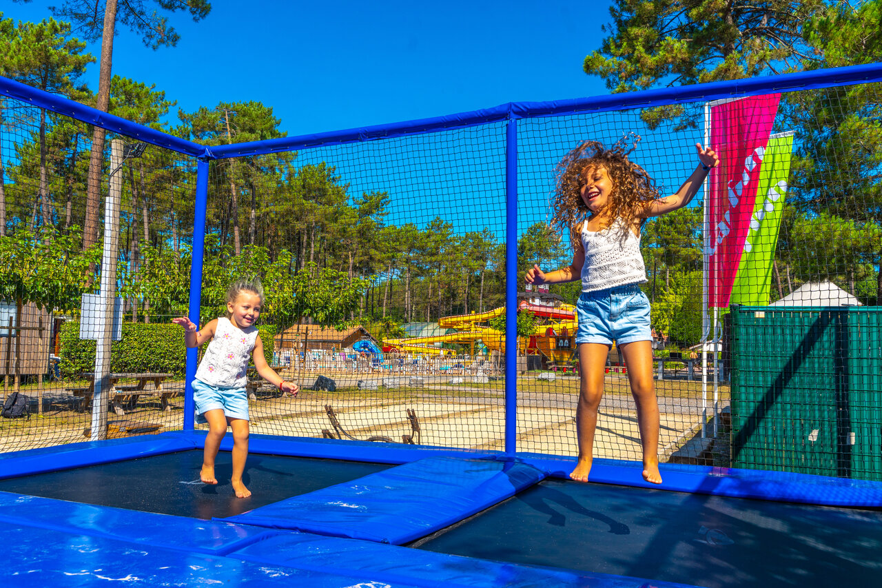 Blije kinderen springen op trampolines op camping CAPFUN Pomme de Pin in Saubion (40).