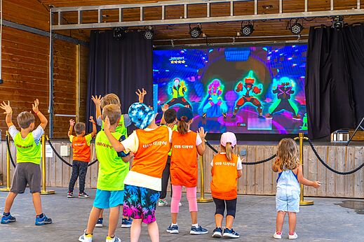 Kinderen doen mee aan interactieve animatie op groot scherm op camping CAPFUN Pomme de Pin in Saubion (40).