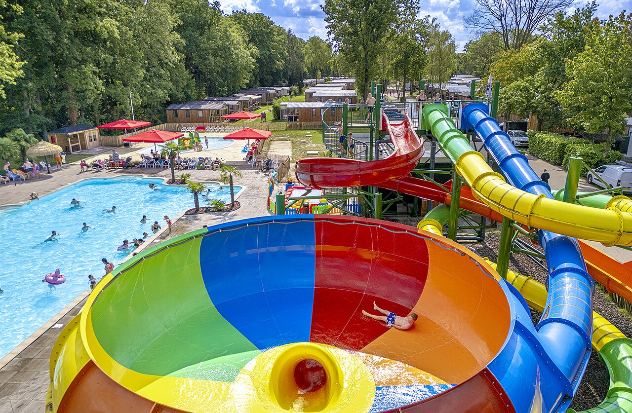 Reuzenglijbaan, zwembad en stacaravans op camping CAPFUN Ponderosa in Ulicoten.