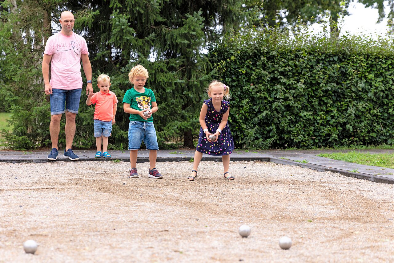 Familie speelt jeu de boules op baan bij CAPFUN Ponderosa in Ulicoten.