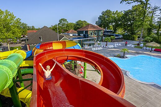 Kleurrijke reuzenglijbaan en buitenzwembad op camping CAPFUN Ponderosa in Ulicoten.