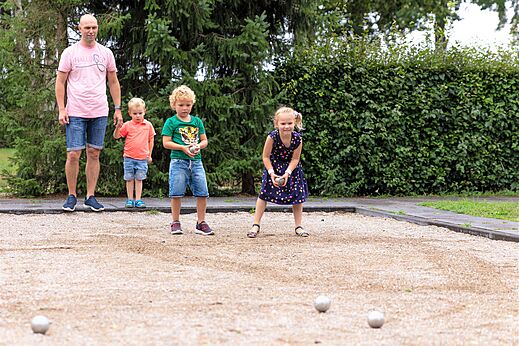 Familie speelt jeu de boules op het terrein van camping CAPFUN Ponderosa in Ulicoten.