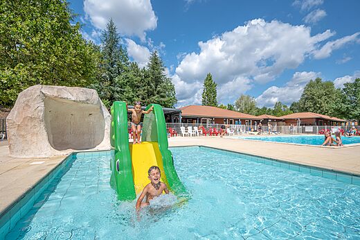 Waterglijbaan en zwembad met kinderen op camping CAPFUN Les Portes du Beaujolais in Anse.