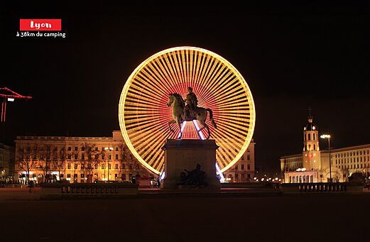 Verlicht reuzenrad en ruiterstandbeeld in Lyon, stad te bezoeken in Rhône-Alpes.