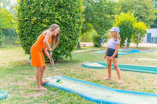 Minigolf met twee jonge meisjes spelend op camping CAPFUN Les Portes du Beaujolais in Anse (69).