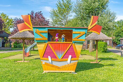 Kleurrijke speelstructuur met poppen en glijbaan op camping CAPFUN Les Portes du Beaujolais in Anse (69).