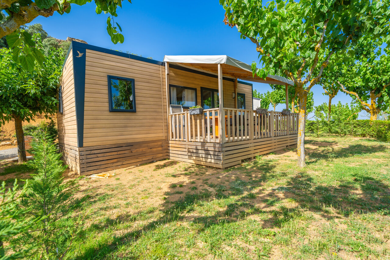 Moderne stacaravan met houten terras en buitenmeubilair op camping CAPFUN Serra de Prades in Vilanova de Prades (43).