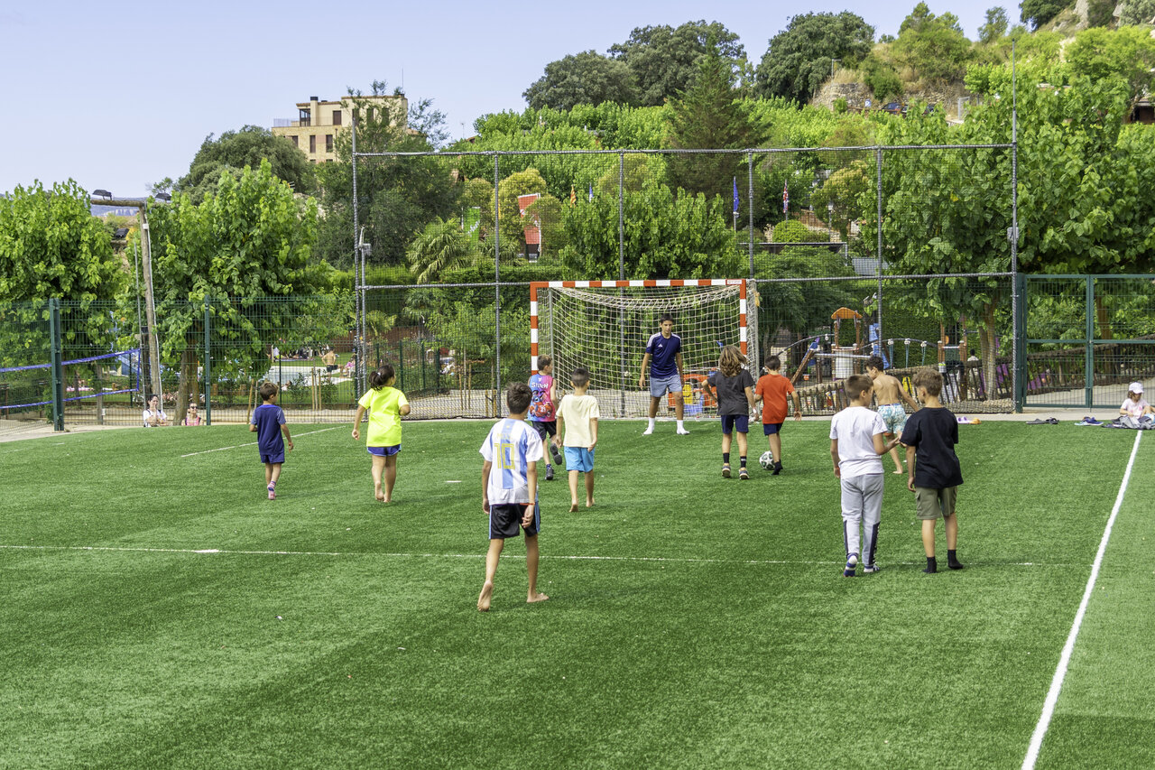 Kinderen voetballen op multisportterrein camping CAPFUN Serra de Prades in Vilanova de Prades.