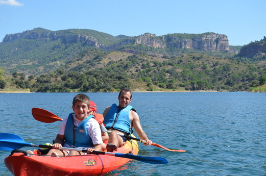 Vader en kind kajakken op het meer op camping CAPFUN Serra de Prades in Vilanova de Prades.