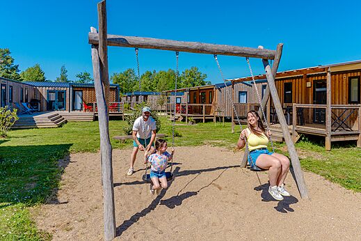 Spelen, blije familie op de schommels op camping VAGUES OCEANES Près de la Fontaine à Gouaix (77).