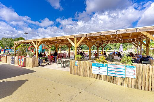 Schaduwrijk restaurantterras en kinderspeeltuin op camping VAGUES OCEANES in Gouaix.