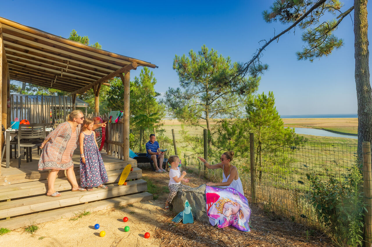 Familie op Mobil-home terras met zeezicht op CAPFUN Prises camping in La TRANCHE SUR MER (85).