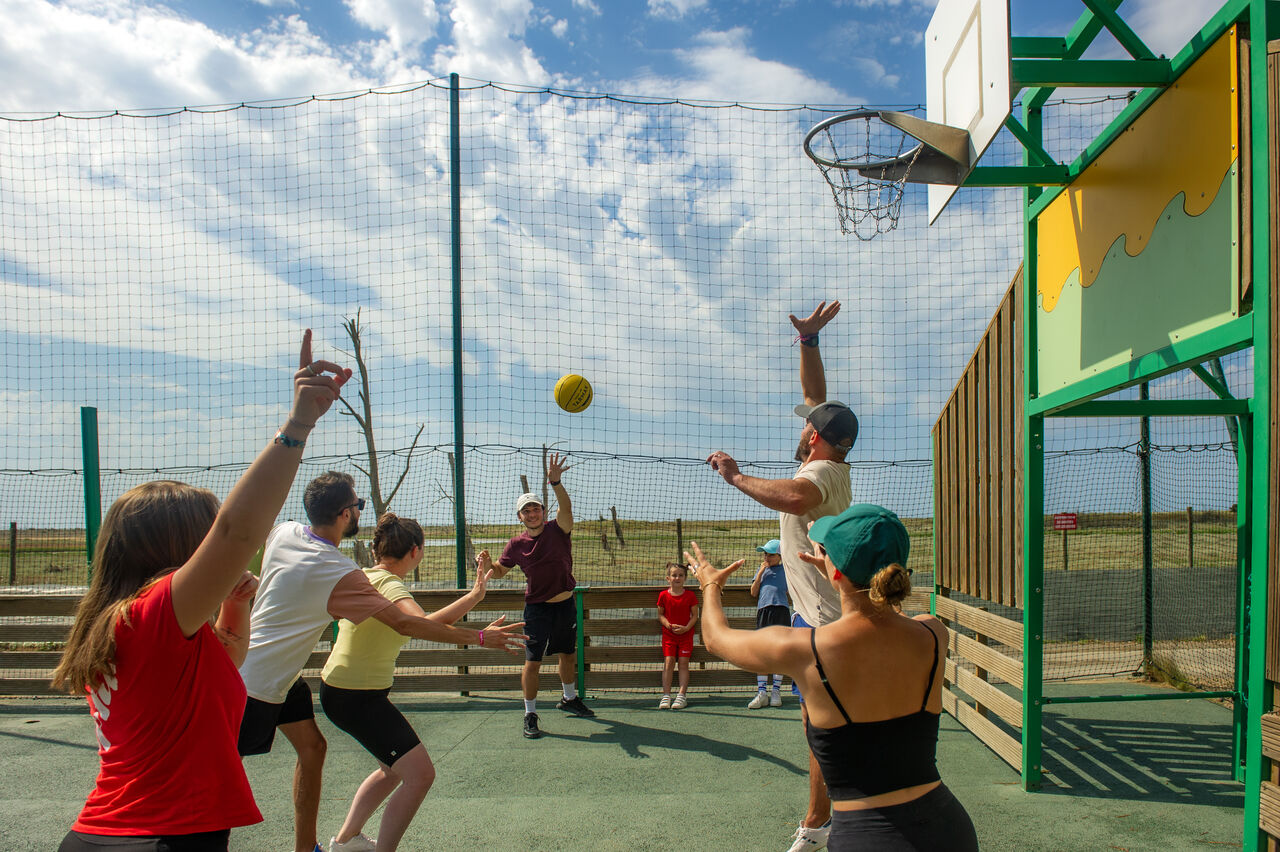 Familie speelt basketbal op multisportterrein op camping CAPFUN Prises in La TRANCHE SUR MER (85).